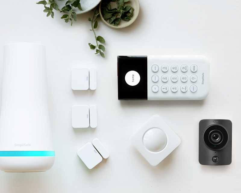 UK Package Essentials, showcasing a base station, motion detector, camera, and entry sensors.